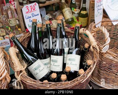 Bottles of Local Cider for sale, in a wicker basket, Honfleur, Normandy, France, Stock Photo