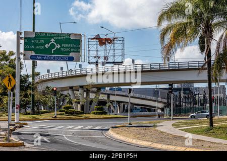 Zapopan, Jalisco Mexico. January 1, 2023. Cityscape of vehicular bridge with curvy overpass on Avenida Acueducto against blue sky, street, signs indic Stock Photo