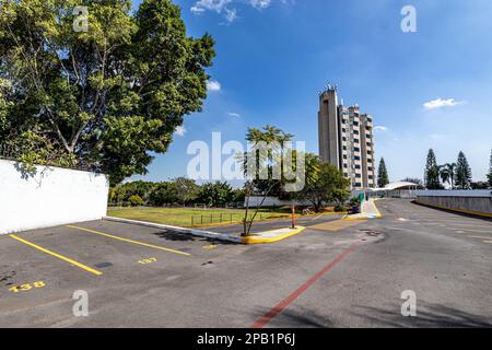 Zapopan, Jalisco Mexico. January 1, 2023. Empty street with places to park cars, modern building against a blue sky on a sunny day in the background, Stock Photo