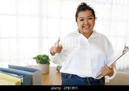 Friendly cheerful young woman social worker posing at office Stock Photo