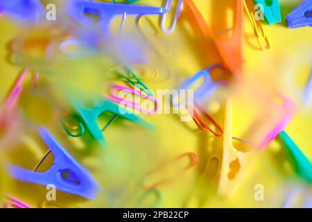 Abstract bright background with blurred clothespins and paper clips on a yellow background Stock Photo