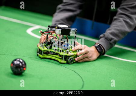 Berlin, Germany. 12th Mar, 2023. A participant puts his robot on the field at the Soccer qualifying tournament of the RoboCup Junior competition. There are 164 students from 14 schools and institutions participating in RoboCup Junior in Germany. Credit: Fabian Sommer/dpa/Alamy Live News Stock Photo