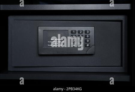 Black steel safe box with electronic security lock. Modern safety locker in a hotel room or at home. Stock Photo