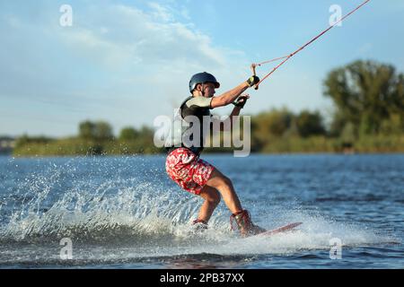 Teenage boy wakeboarding on river. Extreme water sport Stock Photo