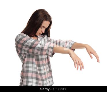 Young woman wearing pajamas in sleepwalking state on white background Stock Photo