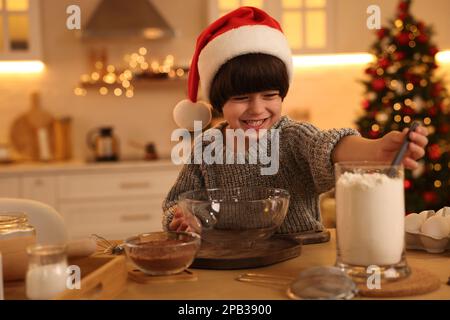 Cute little boy making Christmas cookies in kitchen Stock Photo