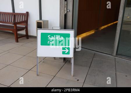 A Little Sign Board to Show Exit Way Both in English and Spanish (Bilingual) Stock Photo