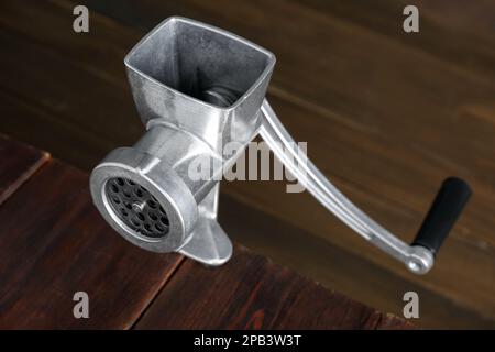 https://l450v.alamy.com/450v/2pb3w3t/metal-manual-meat-grinder-on-wooden-table-closeup-2pb3w3t.jpg