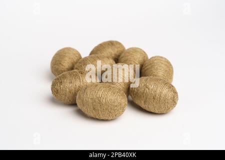 Hand wrapped easter eggs with jute twine, isolated white background. Studio Stock Photo