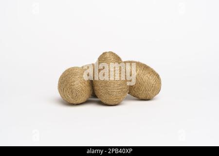 Hand wrapped easter eggs with jute twine, isolated white background. Studio Stock Photo