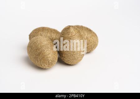 Hand wrapped easter eggs with jute twine, isolated white background. Studio Stock Photo
