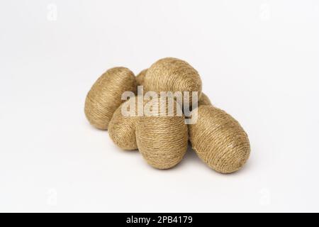 Hand wrapped easter eggs with jute twine, isolated white background. Studio Stock Photo