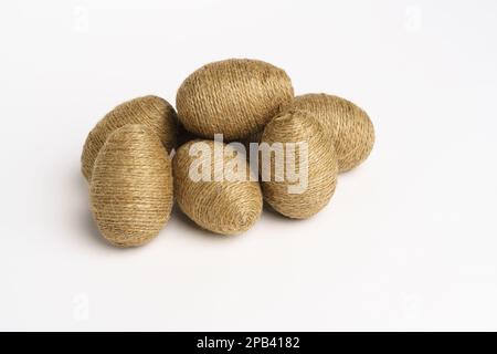Hand wrapped easter eggs with jute twine, isolated white background. Studio Stock Photo