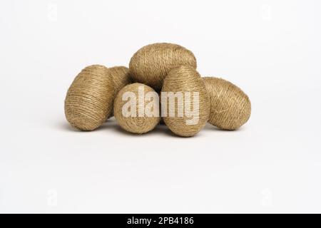 Hand wrapped easter eggs with jute twine, isolated white background. Studio Stock Photo