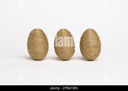 Hand wrapped easter eggs with jute twine, isolated white background. Studio Stock Photo