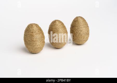 Hand wrapped easter eggs with jute twine, isolated white background. Studio Stock Photo
