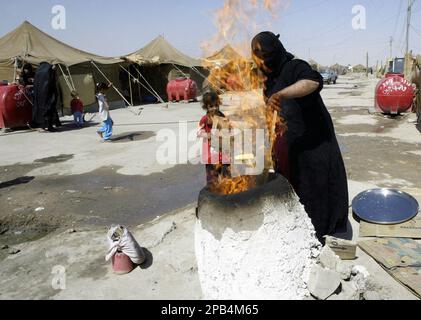 An Iraqi Shiite woman bakes bread in a camp outside of Najaf, 160 kilometers (100 miles) south of Baghdad, Iraq on Tuesday, Sept. 11, 2007. The United Nations' refugee agency estimates that about 2,000 Iraqis leave their homes every day due to violence and economic uncertainty resulting from the four-year conflict. (AP Photo/Alaa al-Marjani)