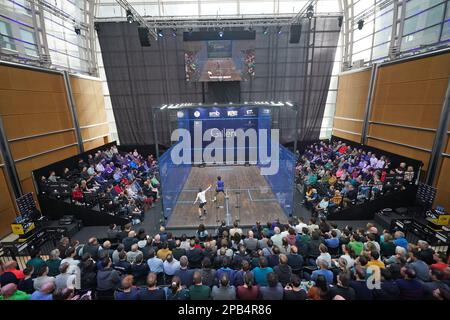 The crowd watch the action from the round one BO3 match between Victor Crouin (left, white top) and Sebastien Bonmalais during the Canary Wharf Squash Classic at the East Wintergarden, London. Picture date: Saturday March 12, 2023. Stock Photo