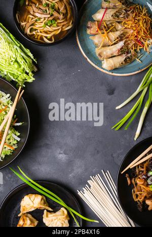 Chinese food dark background. Chinese noodles, fried rice, noodle soup, dim sum, spring rolls, salad. Traditional Chinese cuisine dishes set. Space fo Stock Photo