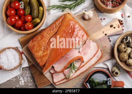 Flat lay composition with delicious smoked bacon on wooden table Stock Photo