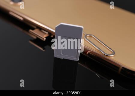 SIM card, smartphone and ejector on black background, closeup Stock Photo