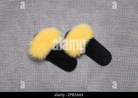 Slippers on soft grey bath mat, flat lay Stock Photo