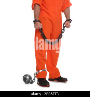 Prisoner in jumpsuit with chained hands and metal ball on white background, closeup Stock Photo