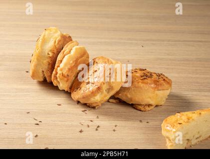 National Hungarian cumin buns randomly lie on a wooden background. Stock Photo
