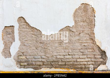 Background texture of an old bricked house wall with cracked paint Stock Photo