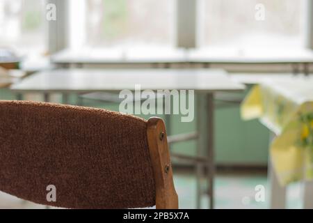 Chairs, a window and a table in an abandoned and dilapidated holiday house in the style of the People's Republic of Poland. Stock Photo
