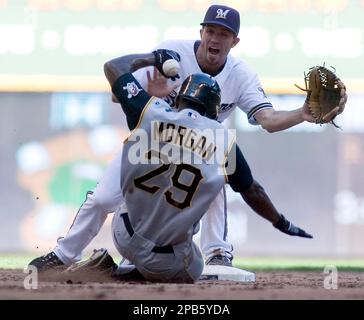 Milwaukee Brewers' J.J. Hardy (L) is safe at third base as San Diego Padres  tries to throw out Ryan Braun at second base during the fifth inning at  Miller Park on September