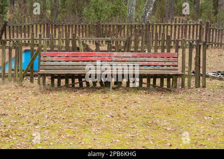 A dilapidated and forgotten bench in an abandoned resort on a gloomy ...