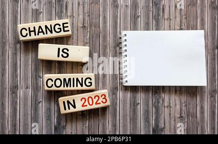 Changes are coming in 2023. Conceptual word Changes that will happen in 2023 on wooden blocks next to a notepad for writing. Beautiful wooden backgrou Stock Photo