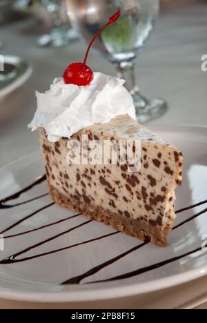 Chocolate chip cheesecake with whipped topping and a cherry Stock Photo