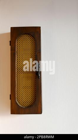 Old narrow wooden box hanging on the wall to store keys or small items Stock Photo