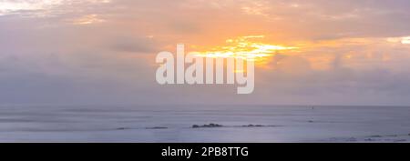 Colorful sky with horizon at sea after sunset during evening time. Stock Photo