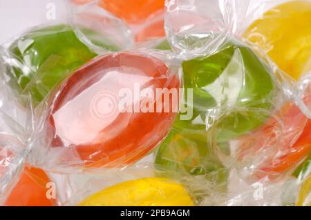 Detailed close-up of a vibrant assortment of multi-colored hard candies or sweets in a colorful pile. Stock Photo