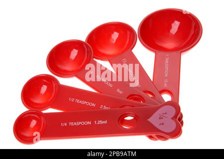 Measuring spoons, cooking utensils and kitchen items, red with pink heart, made of plastic, tablespoons and teaspoons measuring by Imperial System Stock Photo