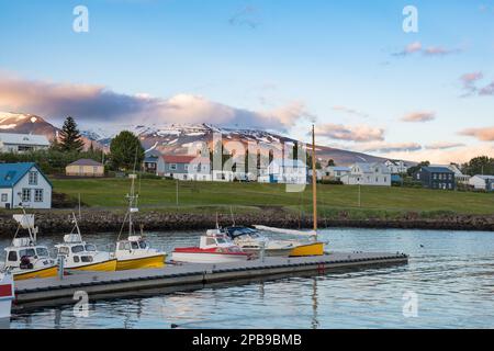 View over the boats in port of Hrisey in North Iceland towards the village Stock Photo