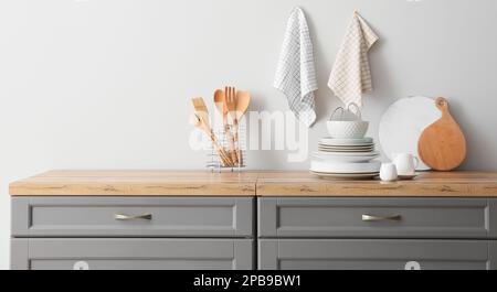 Set of clean dishes and utensils on table in kitchen Stock Photo