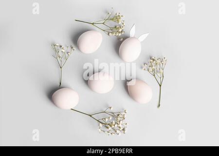 Composition with Easter eggs and gypsophila flowers on light background Stock Photo