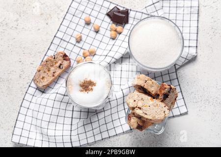 Delicious biscotti cookies, hazelnuts, chocolate and cup of coffee on napkin Stock Photo