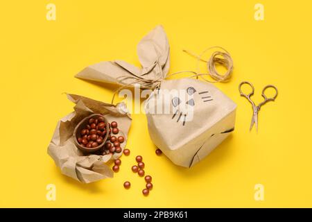 Easter bunny gift bag, candies and scissors on yellow background Stock Photo