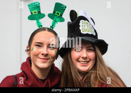 London, UK. 12th Mar, 2023. Two young women pose before participating in the parade. The annual St Patrick's Day Parade makes its way through central London to celebrate London's Irish community and Irish culture and heritage with participants in costumes, marching bands, pageantry and more, watched by spectators along the route. Credit: Imageplotter/Alamy Live News Stock Photo