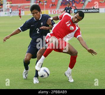 Thailand's Suree Sukha, left, fights for the ball with Oman's