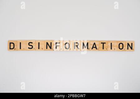 Wooden title spelling the word disinformation isolated on a white background Stock Photo