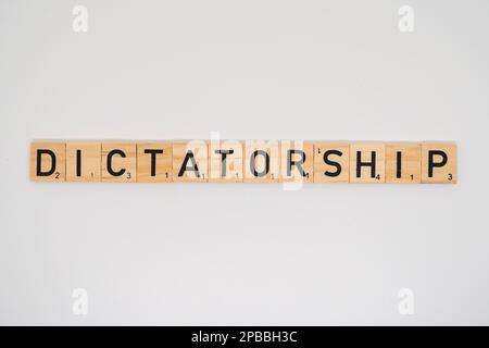 Wooden title spelling the word dictatoridhip.isolated on a white background Stock Photo