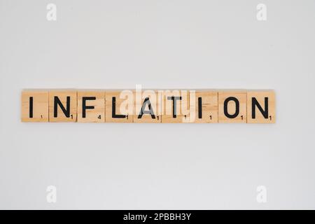 Wooden title spelling the word inflation isolated on a white background Stock Photo