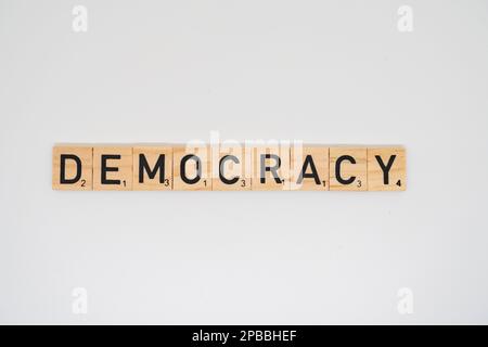 Wooden title spelling the word democracy isolated on a white background Stock Photo