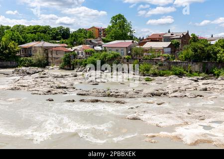 Rioni river in Kutaisi, landscape view with white stones and residential houses on the river bank, view from White Bridge, summer, Georgia. Stock Photo